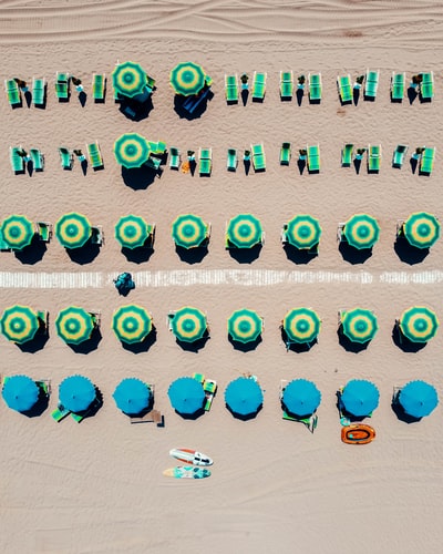 The people on the beach under the blue and white umbrella
